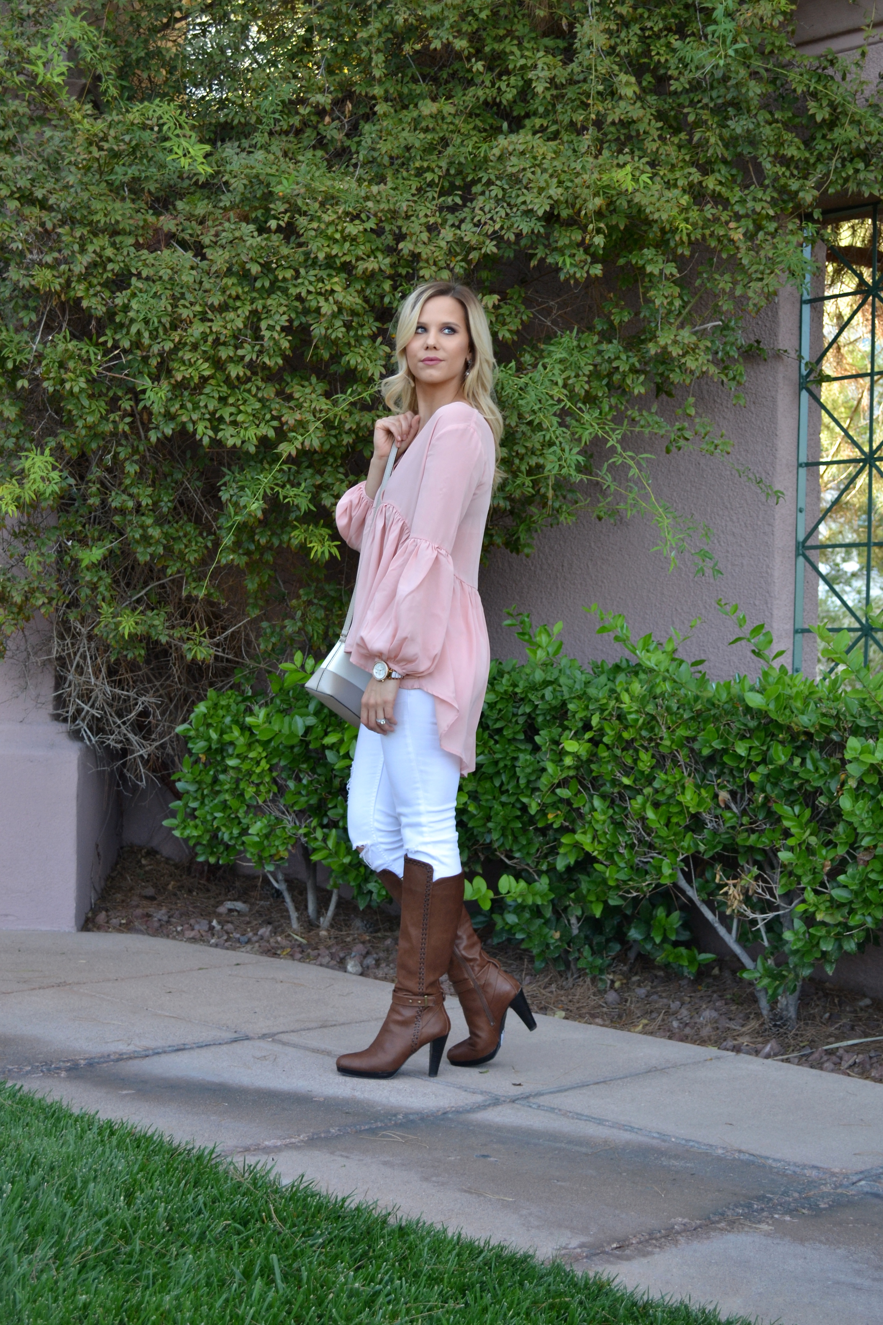 $22 Pink High Low Blouse with white jeans and boots on glamlifeliving.com
