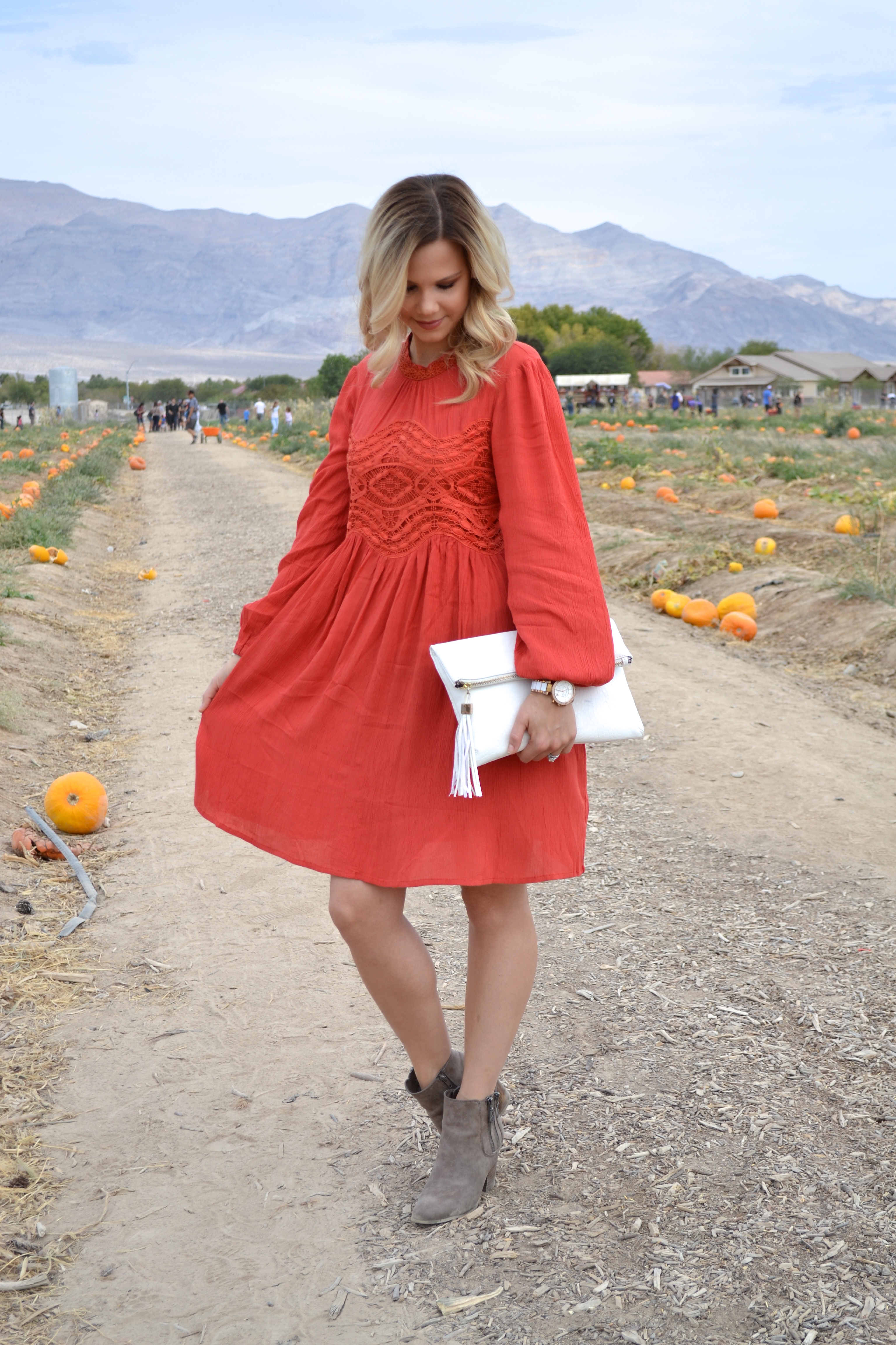 Long Sleeve Orange Dress with White Clutch and Booties on Glam Life Living 