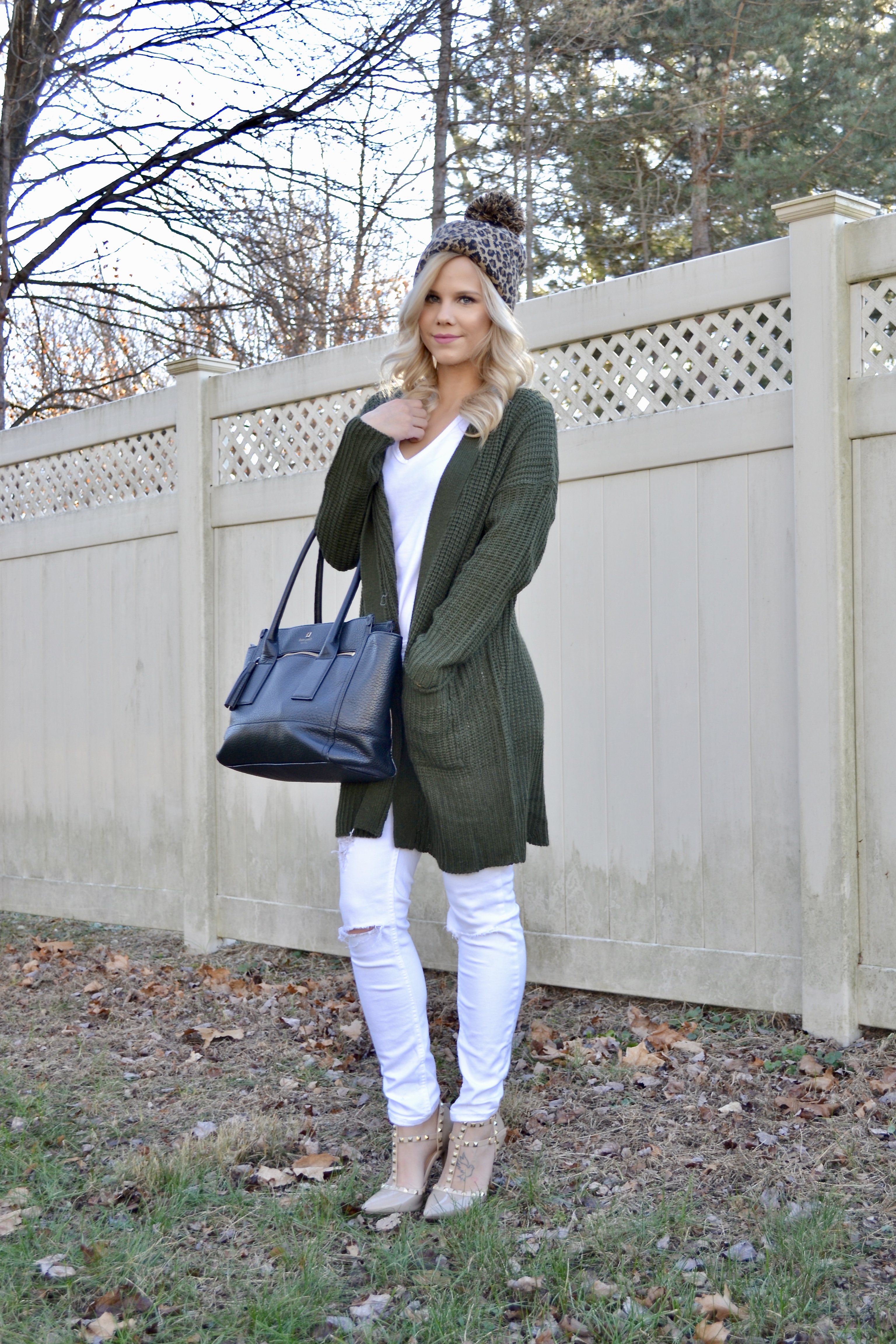 white jeans, green cardigan, Valentino dupes, black Kate Spade tote and cheetah print beanie with pom