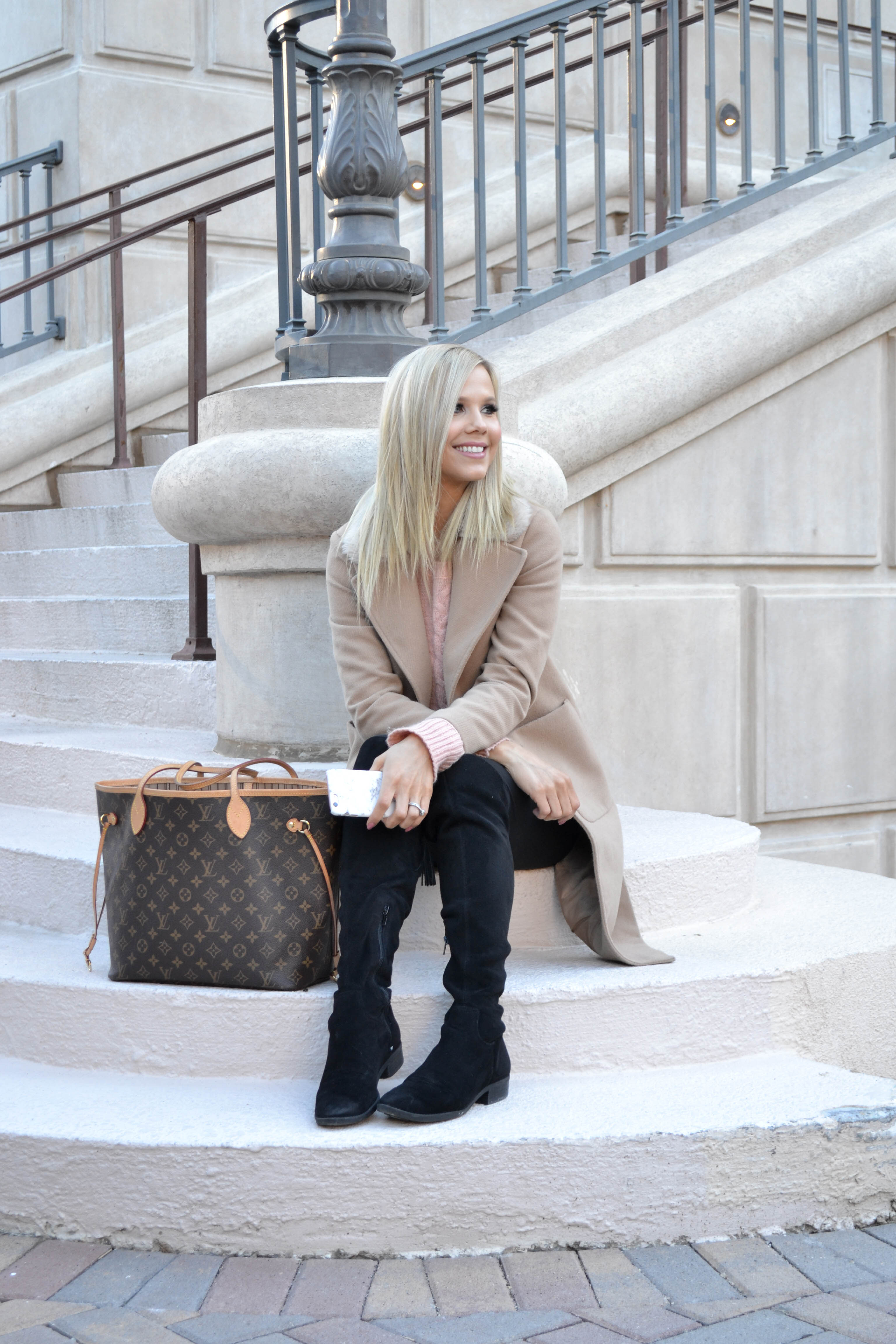 tan winter coat with fur trim and black over the knee boots