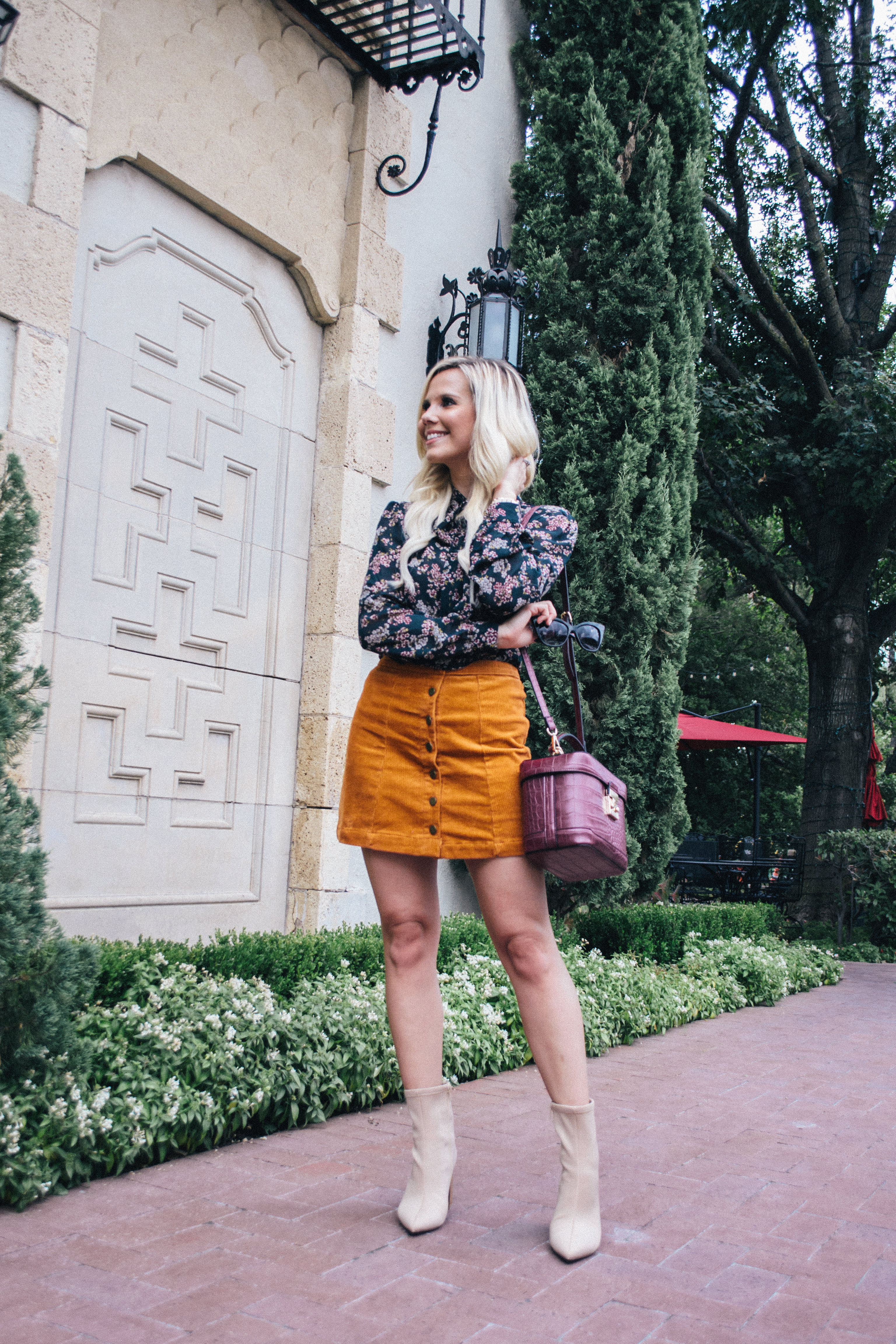 Budget friendly fall and in-between seasons outfit with floral long sleeve blouse and button corduroy mini skirt from Hannah McDonnell of Glam Life Living a Dallas based fashion blogger #fashion #fall #style #falloutfit