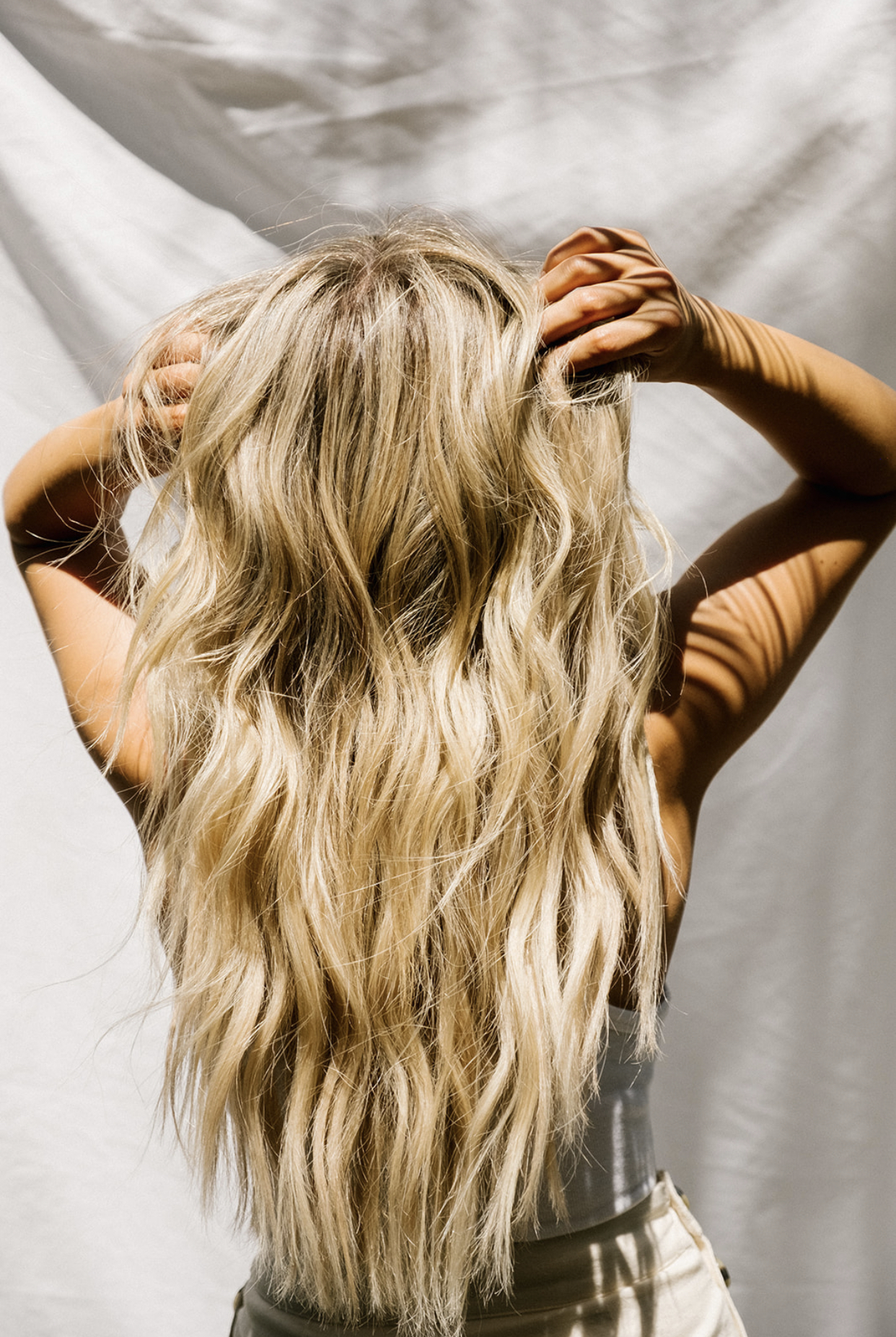 How to style your long blonde hand tied hair extensions is easy with the GHD 1.25 curling iron, which is perfect for natural looking waves! #handtiedextensions #extensions